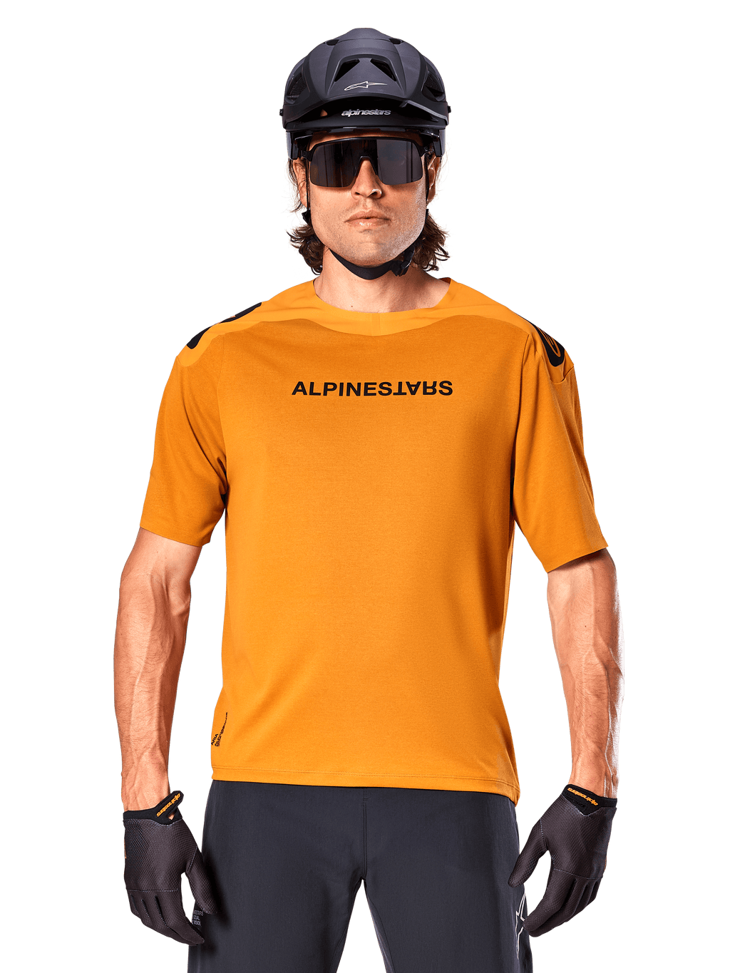 Alpinestars A-Aria Polartec Switch Jersey - Manga Curta, Dourado Escuro, ciclista de BTT a usar capacete preto e óculos de sol, vestuário de ciclismo de performance para trilhos de BTT