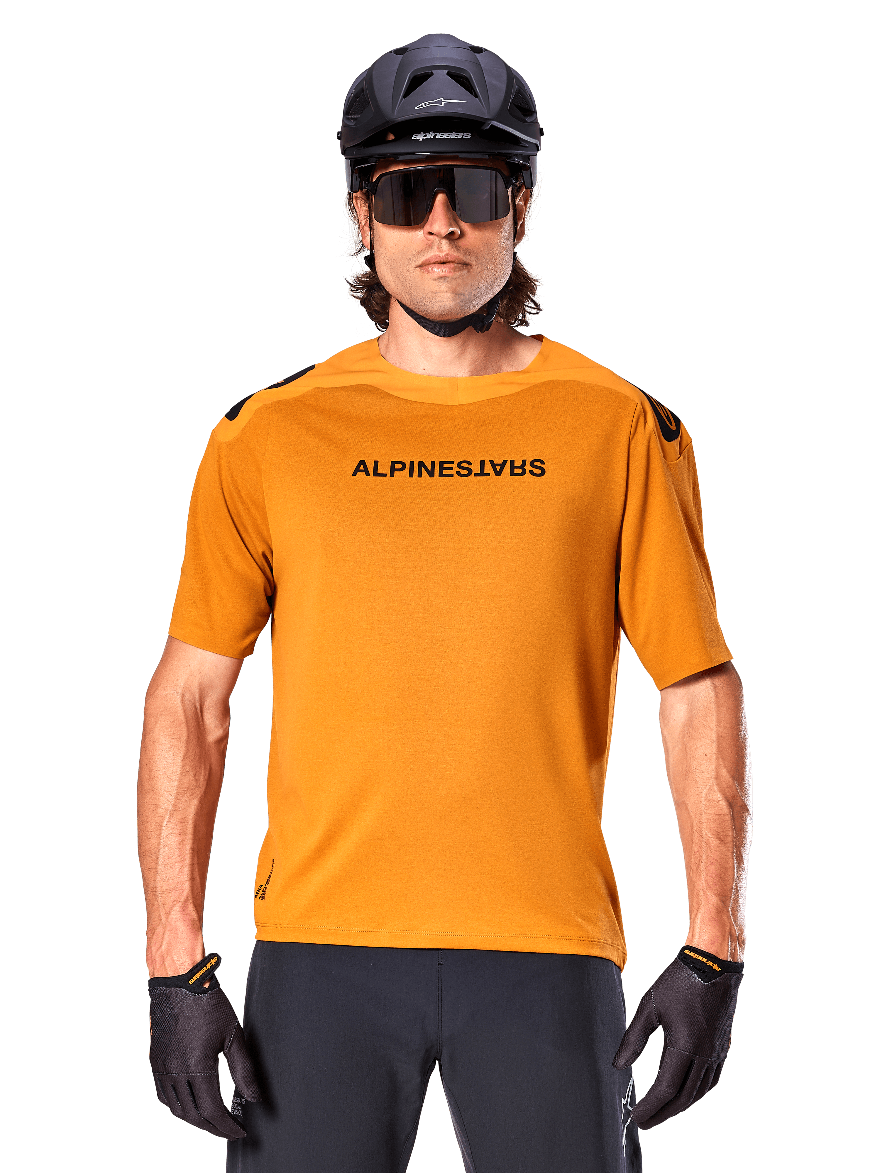 Alpinestars A-Aria Polartec Switch Jersey - Manga Curta, Dourado Escuro, ciclista de BTT a usar capacete preto e óculos de sol, vestuário de ciclismo de performance para trilhos de BTT