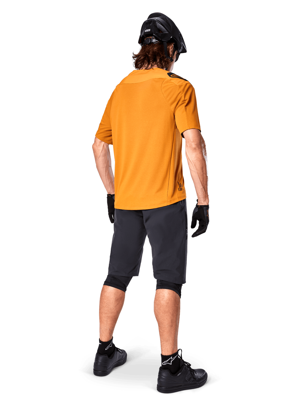 Alpinestars A-Aria Polartec Switch Jersey, camisola de BTT de manga curta, amarela, vista traseira de modelo a usar calções de BTT cinzento escuro, capacete preto e luvas, vestuário técnico de ciclismo para trilhos fora de estrada