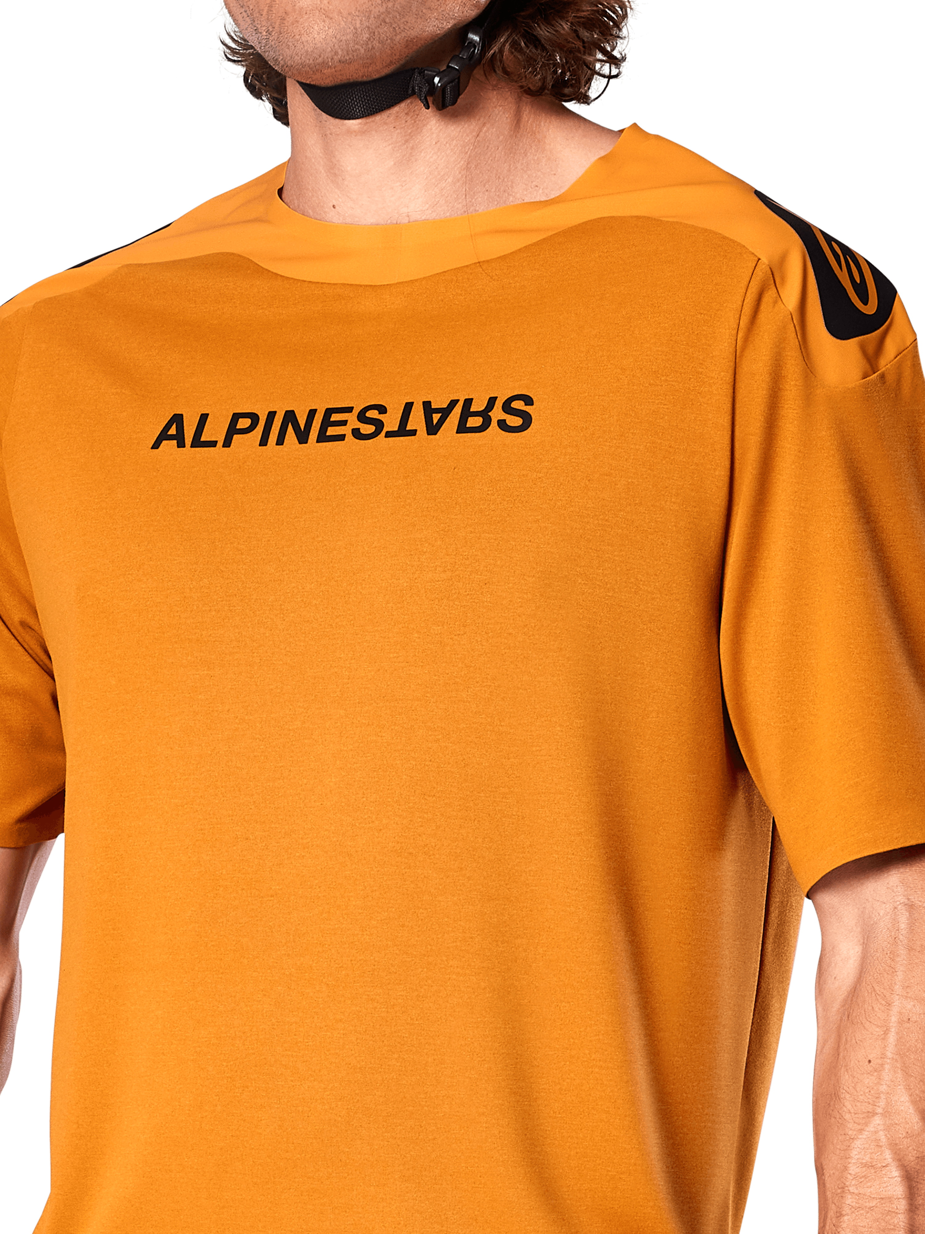 Alpinestars A-Aria Polartec Switch Jersey, camisola de manga curta para BTT, cor ouro escuro, com logótipo Alpinestars preto espelhado no peito, tecido de desempenho técnico para a prática de trilhos de BTT