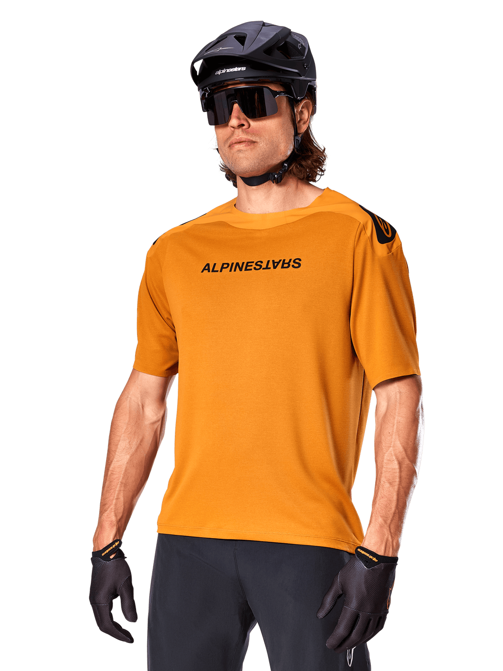 Alpinestars A-Aria Polartec Switch Jersey, camisola de BTT de manga curta, Dark Gold com logótipo preto, usada por um modelo com capacete preto, óculos de sol e luvas de ciclismo, vestuário de BTT de alta performance