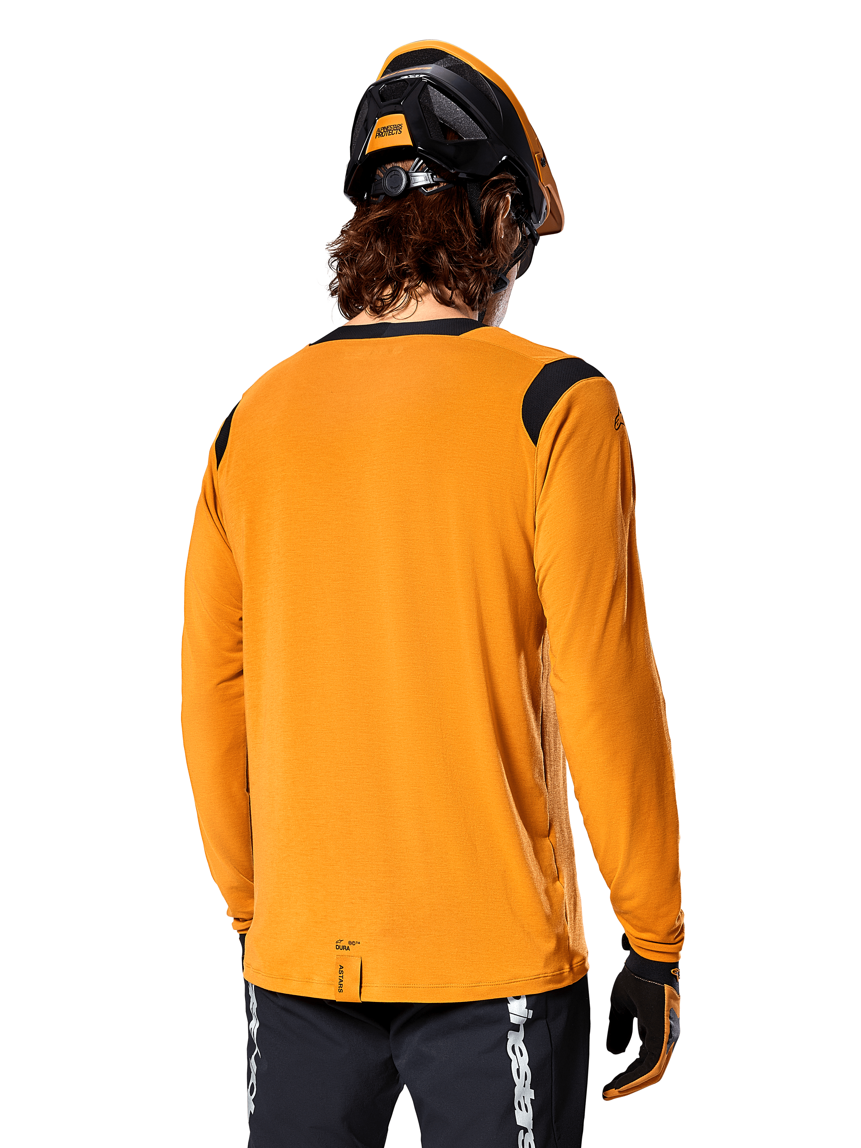 Camisola de Manga Comprida Alpinestars A-Dura Dri Wool em Dark Gold, vista traseira de um ciclista com capacete de BTT e luvas, apresentando painéis de malha pretos nos ombros e uma cauda mais longa, vestuário técnico de ciclismo para trilhos