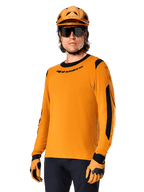 Alpinestars A-Dura Dri Wool Jersey - Long Sleeve, camisola de BTT de manga comprida, dourado escuro e preto, com mistura de lã merino para absorção de humidade e painéis de malha, ciclista com capacete, óculos de sol e luvas a condizer