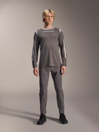 Alpinestars A-Dura Dri Wool Long Sleeve Jersey, Dark Gray, worn by model with matching gray pants and black shoes, white Alpinestars branding on chest, light gray mesh panels on shoulders and sleeves, technical mountain bike gear