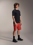 Modelo masculino a usar calções Alpinestars A-Dura Elite em Laranja Escuro e jersey de manga curta A-Dura Dri Wool em preto, equipamento de performance para BTT, combinado com meias e sapatos pretos, design atlético para ciclismo fora de estrada.