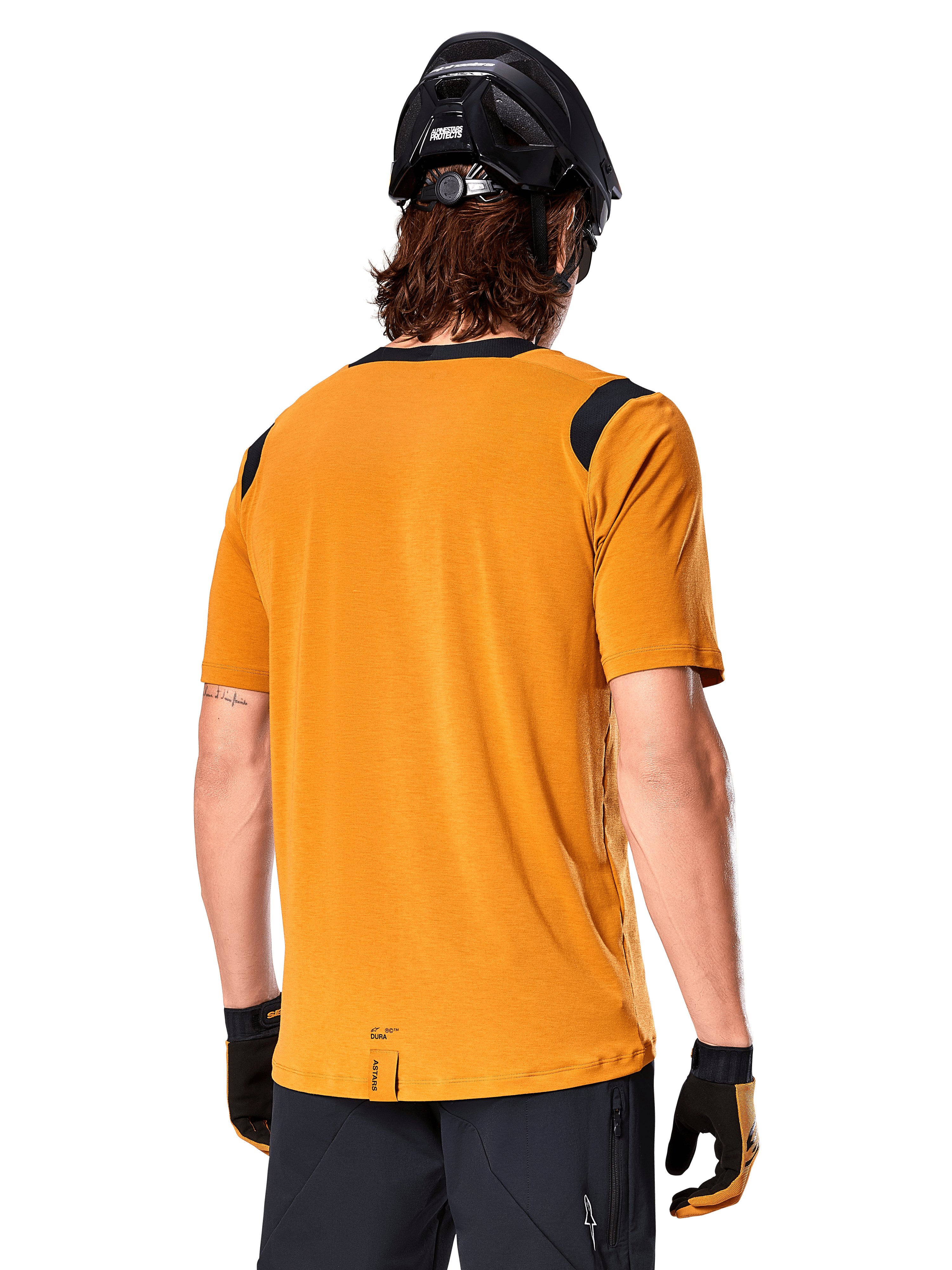 Camisola Alpinestars A-Dura Dri Wool de Manga Curta, Amarelo Escuro, vista traseira de um homem a usar a camisola com painéis de malha pretos nos ombros, combinada com capacete de BTT e luvas pretas, equipamento de ciclismo de montanha de ajuste regular