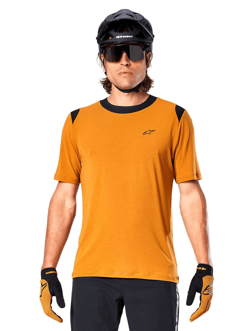 Camisola de Manga Curta Alpinestars A-Dura Dri Wool, dourado escuro, usada com capacete de MTB preto, óculos de sol e luvas, com gola e painéis nos ombros pretos, mistura de lã drirelease respirável para mountain biking