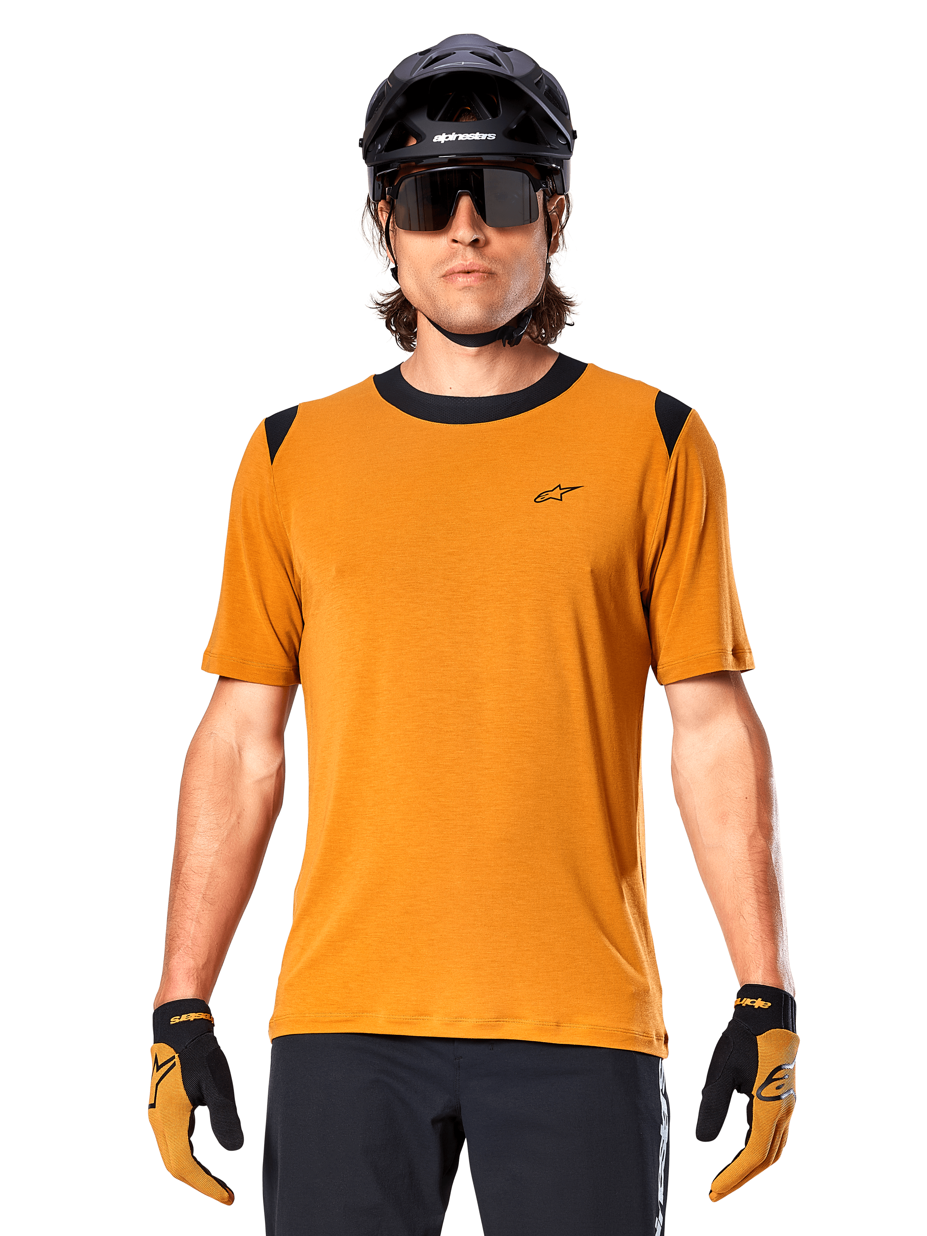 Camisola de Manga Curta Alpinestars A-Dura Dri Wool, dourado escuro, usada com capacete de MTB preto, óculos de sol e luvas, com gola e painéis nos ombros pretos, mistura de lã drirelease respirável para mountain biking
