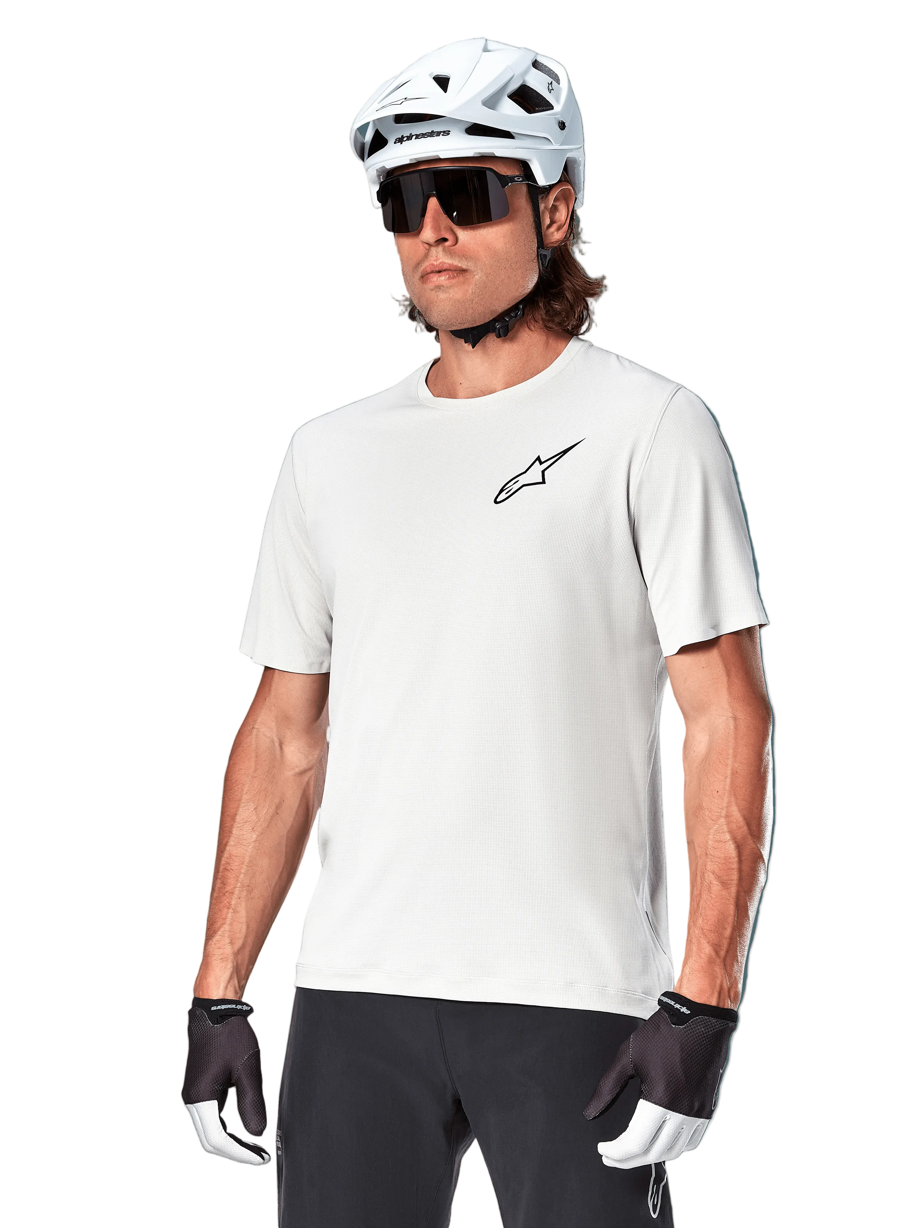 Camisola de manga curta Alpinestars A-Aria Astar, White Dove, vestida por um ciclista com capacete branco e óculos de sol escuros, com um pequeno logótipo de estrela preto no peito, equipamento de performance respirável para BTT