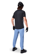 Alpinestars A-Dura Oscar Jersey - Short Sleeve, Black, Rear view of rider wearing a black mountain bike jersey, paired with light blue pants, black helmet, and black gloves, technical MTB apparel for off-road performance