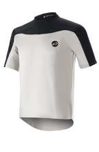 Alpinestars Drop Meta Jersey Short Sleeve, Mountain Biking Jersey, Light Gray and Black, featuring a breathable mesh construction, black shoulder yoke, round neckline, and extended rear tail for coverage.