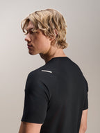 Homem a usar a Camisola Alpinestars A-Aria Switch, Manga Curta, Preta, vista lateral e traseira mostrando o ajuste de performance e pormenores no ombro, vestuário de ciclismo BTT leve e respirável