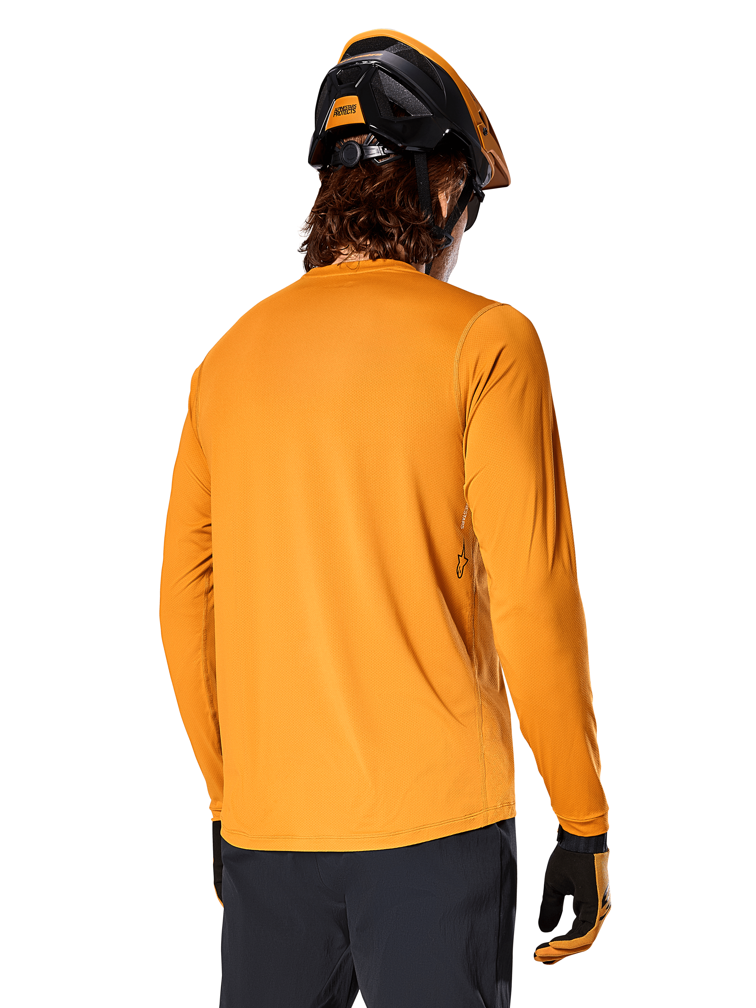Camisola de Manga Comprida Alpinestars A-Dura Rocker, Dark Gold, vista traseira de ciclista com capacete de BTT preto e laranja, calças escuras e luvas a combinar, vestuário casual de performance para bicicleta de montanha