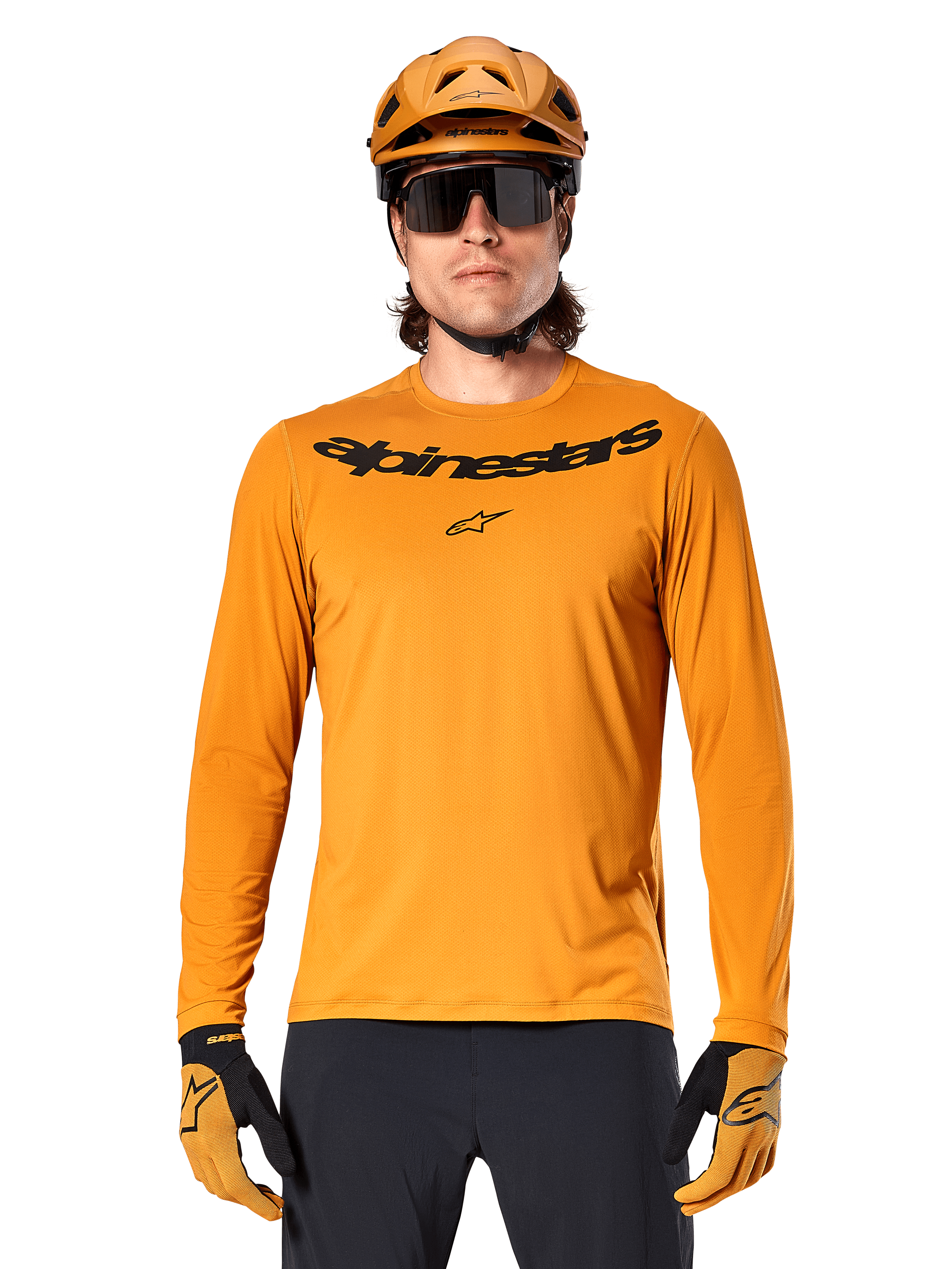 Camisola de manga comprida Alpinestars A-Dura Rocker em dourado escuro, com logótipo da marca em preto no peito, usada com capacete e luvas em dourado a condizer para performance em BTT