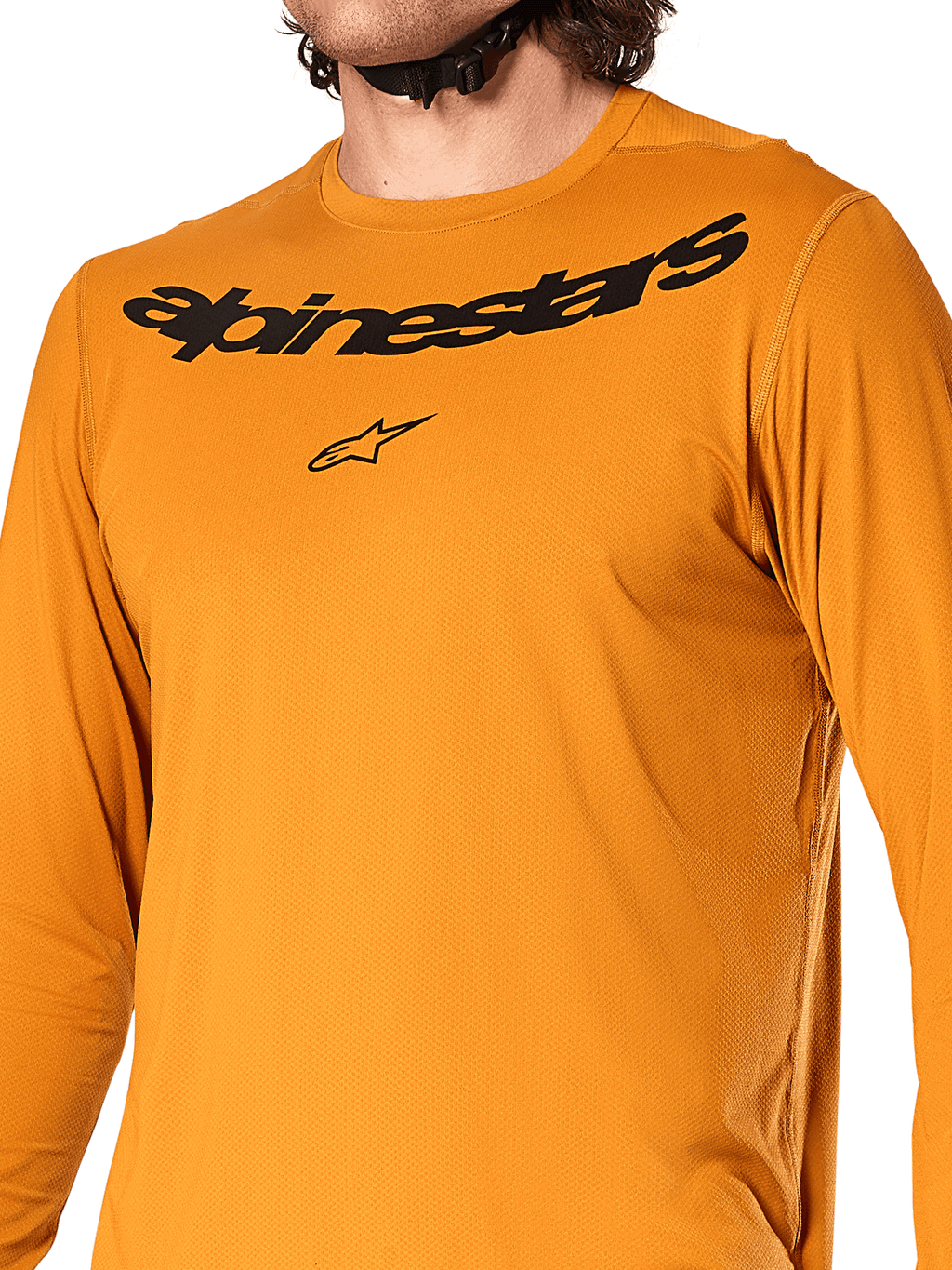 Camisola de manga comprida Alpinestars A-Dura Rocker, ouro escuro, vista detalhada do peito com marca nominativa e logótipo de estrela Alpinestars em preto, tecido jacquard texturizado com absorção de humidade, vestuário de performance para ciclismo MTB