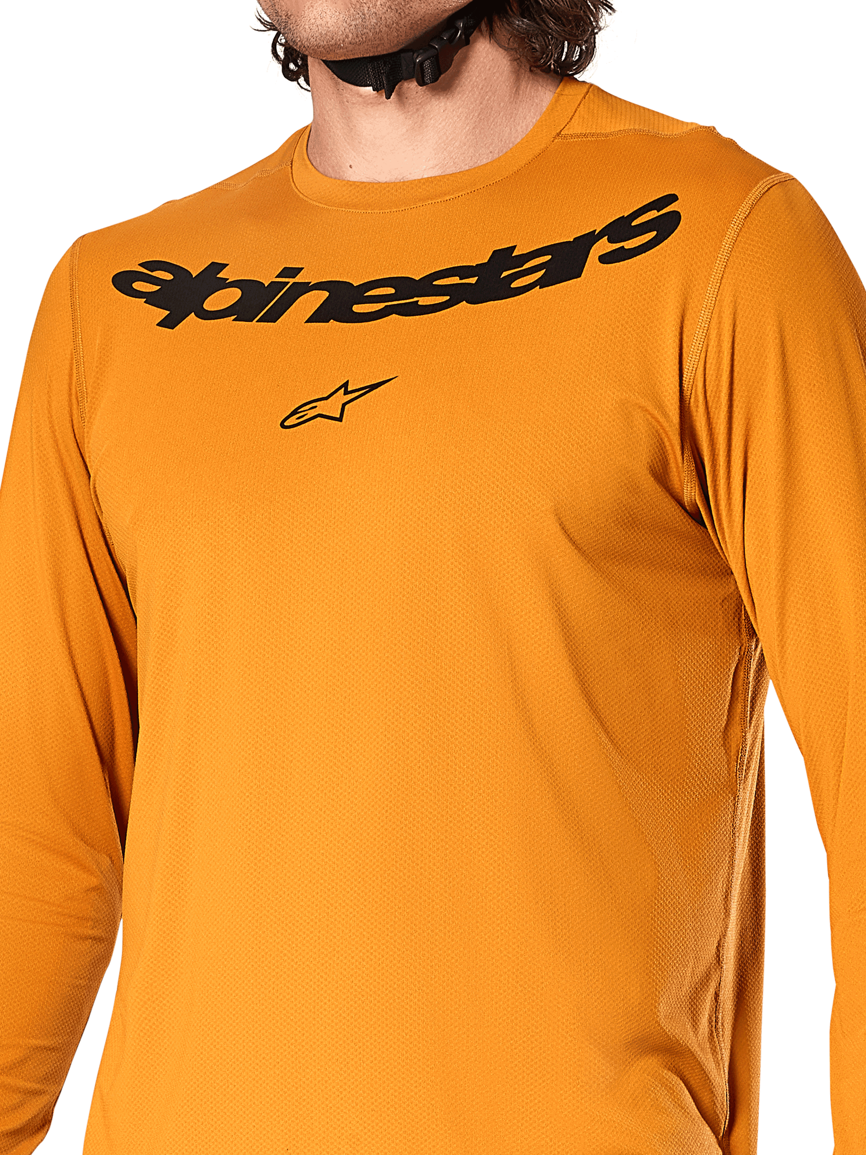 Camisola de manga comprida Alpinestars A-Dura Rocker, ouro escuro, vista detalhada do peito com marca nominativa e logótipo de estrela Alpinestars em preto, tecido jacquard texturizado com absorção de humidade, vestuário de performance para ciclismo MTB