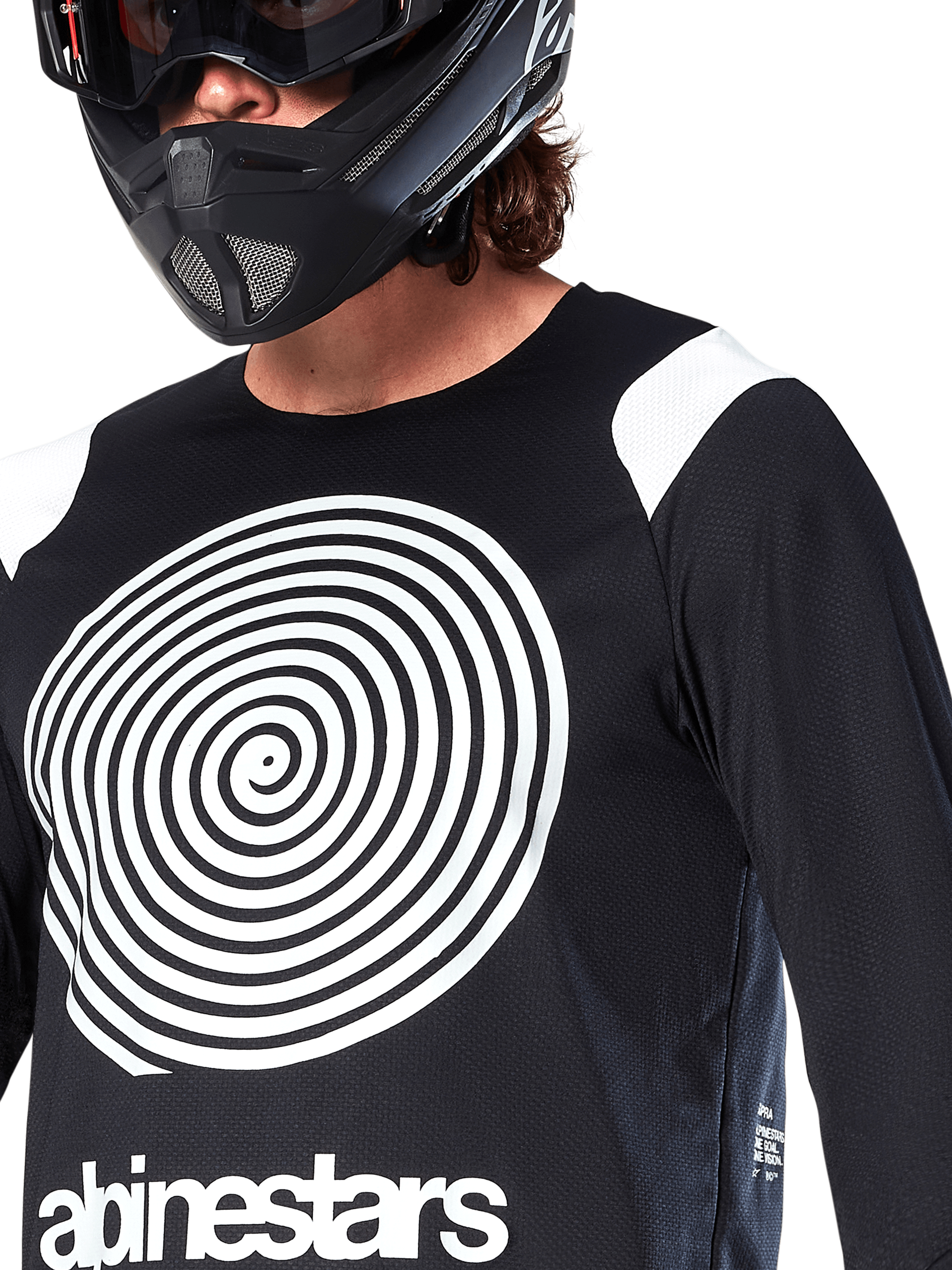 Camisola Alpinestars A-Supra Oscar, de manga comprida, preta, com um grande gráfico em espiral Oscar branco no peito e o logótipo da marca, usada por um ciclista com capacete integral preto e óculos de proteção, vestuário de BTT de performance para modalidades de gravidade