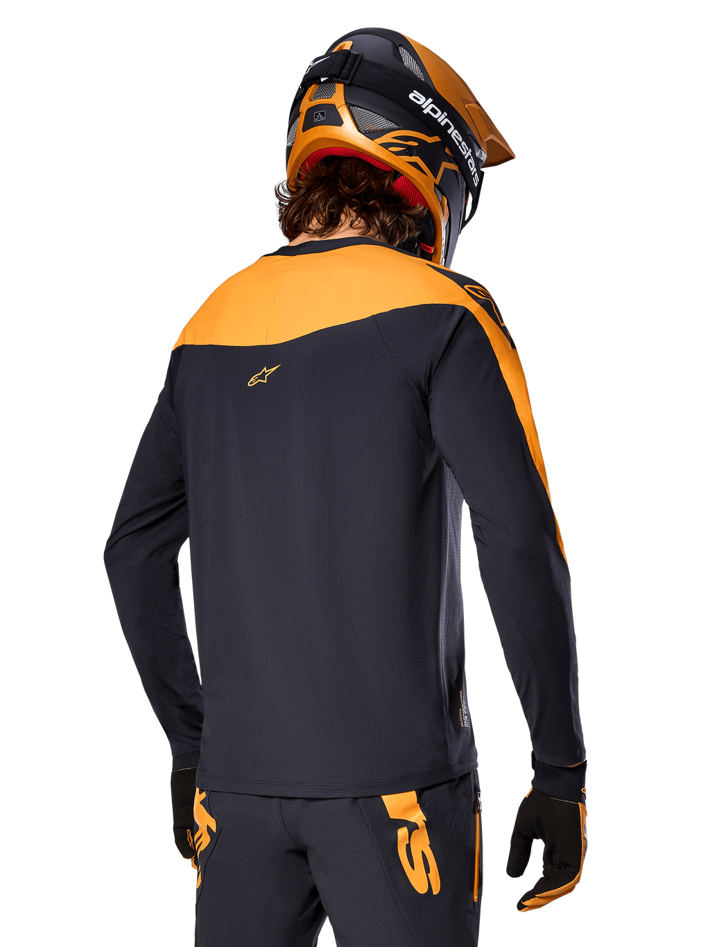 Alpinestars A-Supra Race Jersey - Manga Comprida, preto e laranja, vista traseira de ciclista com capacete e calças de BTT a condizer, ajuste de performance com textura microperfurada, equipamento de corrida profissional de BTT