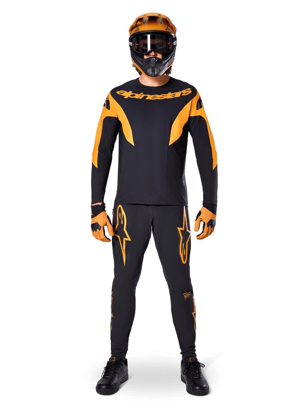 Ciclista de BTT com camisola Alpinestars A-Supra Race - Manga Comprida em preto e laranja, calças, luvas e capacete integral com óculos de proteção a condizer, kit de BTT coordenado para competição e performance fora de estrada