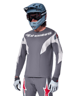 Alpinestars A-Supra Race Jersey - Long Sleeve, Dark Gray with white and red accents, racing-style graphics, worn with matching gray pants, blue full-face helmet, and white gloves, professional MTB and downhill racing gear