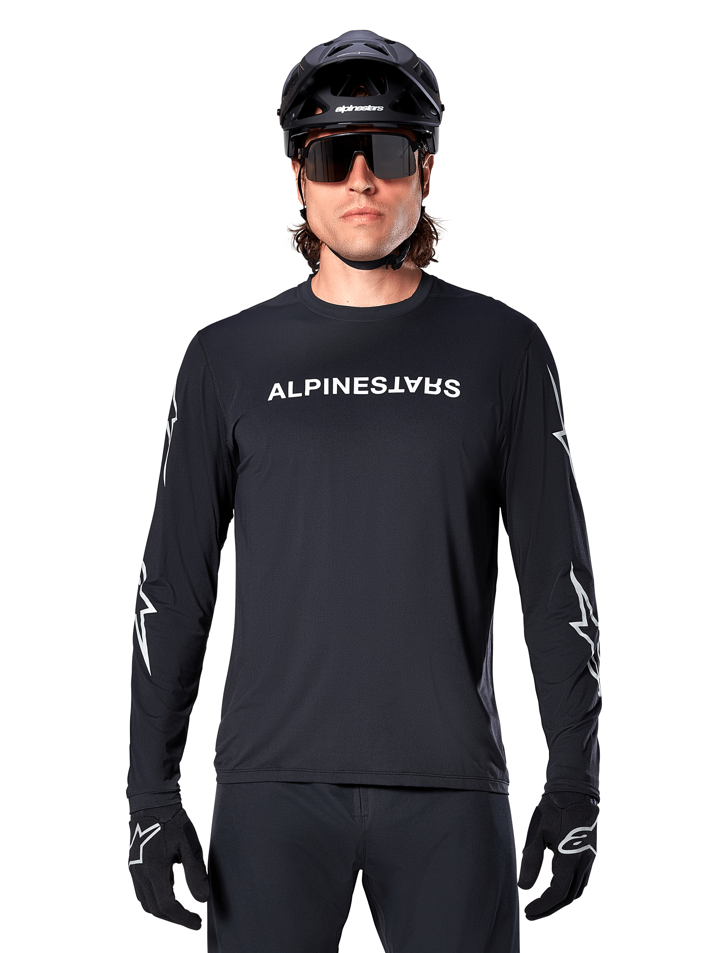 Alpinestars A-Dura Switch Long Sleeve Jersey, Black MTB jersey, white Alpinestars wordmark on chest and star graphics on the sleeves, worn with black mountain bike helmet and performance sunglasses, technical trail riding apparel