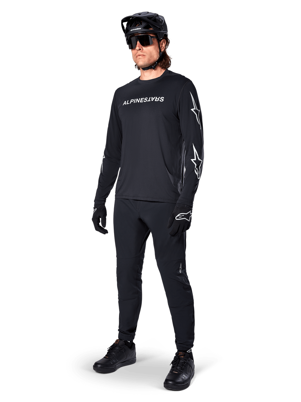 Alpinestars A-Dura Switch Long Sleeve Jersey, Black, mountain bike jersey worn with black pants, helmet, and gloves, featuring white wordmark logo on chest and star logos on sleeves, coordinated MTB gear for off-road riding