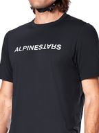 Camisola de manga curta Alpinestars A-Dura Switch, preta, com logótipo branco grande impresso no peito, textura de tecido jacquard de performance, vista frontal aproximada