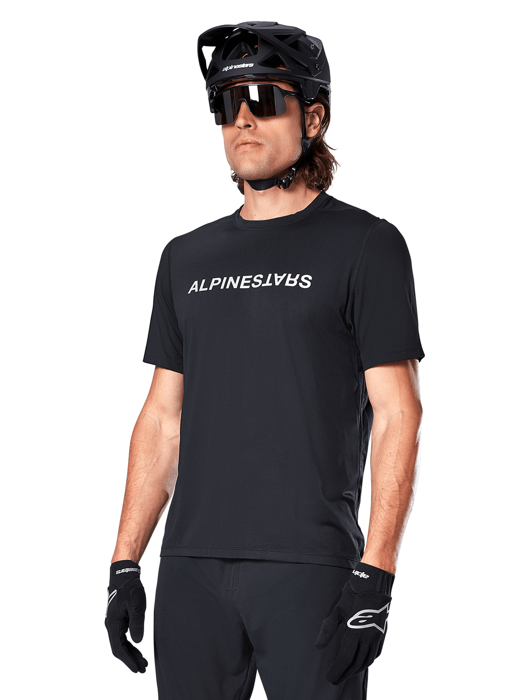 Alpinestars A-Dura Switch Short Sleeve Jersey, preta, com logótipo branco no peito, vestida por um ciclista com capacete de MTB preto e óculos de sol, vestuário técnico concebido para trilhos