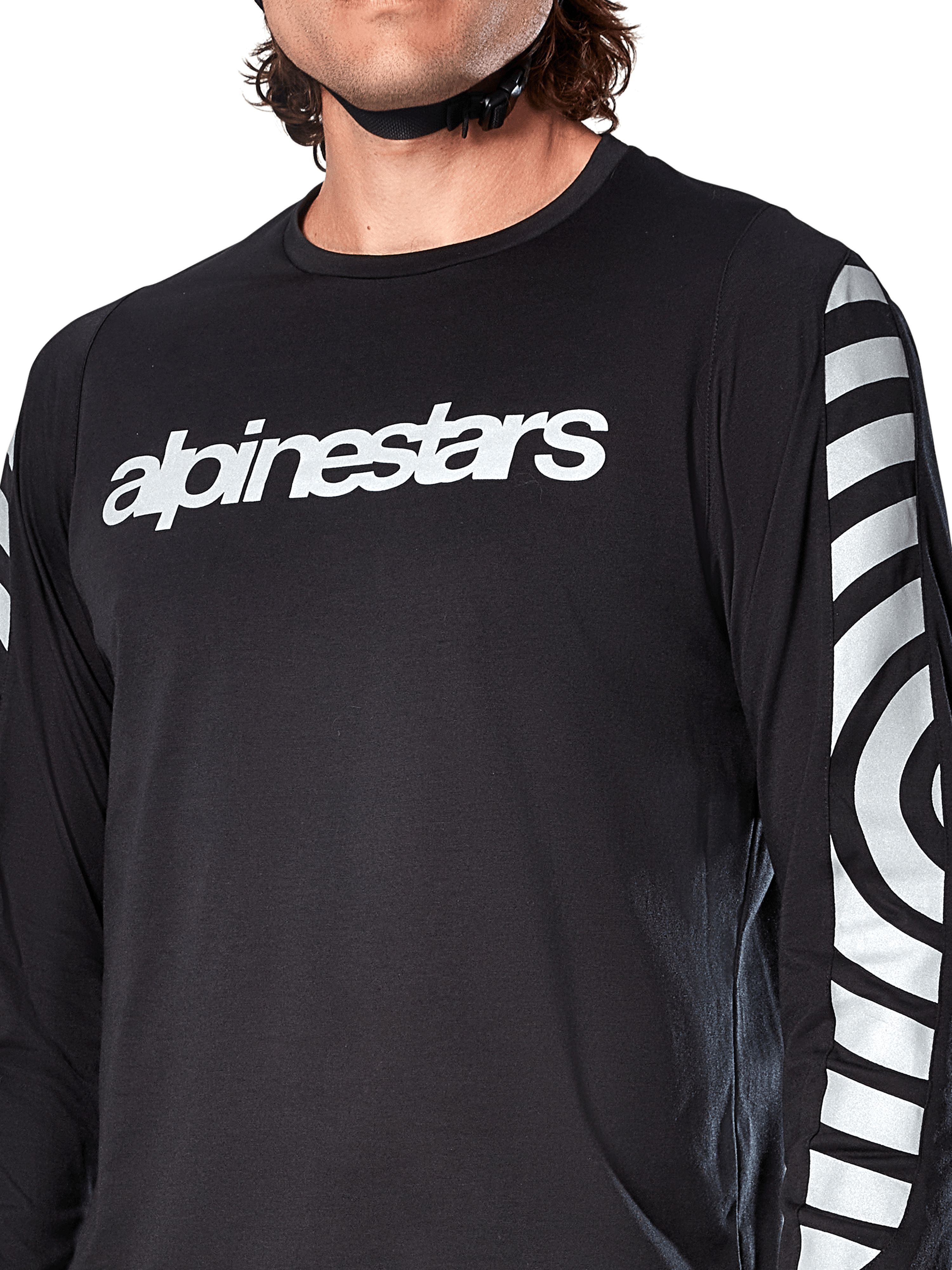 Camisola de Manga Comprida Alpinestars A-Dura Dri Oscar, Preto Refletor, vista em pormenor mostrando o logótipo Alpinestars branco no peito e gráficos circulares refletores nas mangas, vestuário técnico de ciclismo para BTT