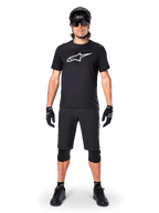 Camisola de Manga Curta Alpinestars A-Dura Dri Oscar, Preto Refletor, usada com calções de BTT pretos a condizer, luvas, joelheiras e capacete, com um logótipo grande da Alpinestars branco no peito, equipamento completo de BTT