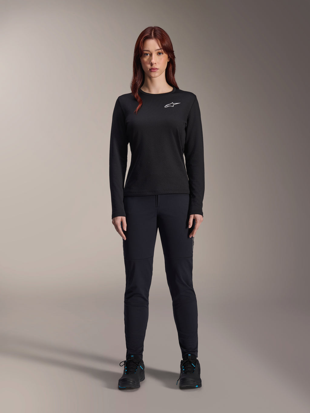 Alpinestars Stella A-Dura Thermal Jersey, Woman's Long-Sleeve Mountain Bike Jersey in Black, featuring a white chest logo, worn with matching black gear and cycling shoes, studio portrait.