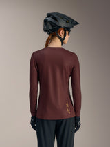 Women's Stella A-Dura Ride Long Sleeve Jersey in Bordeaux, back view with black MTB helmet and Alpinestars branding.