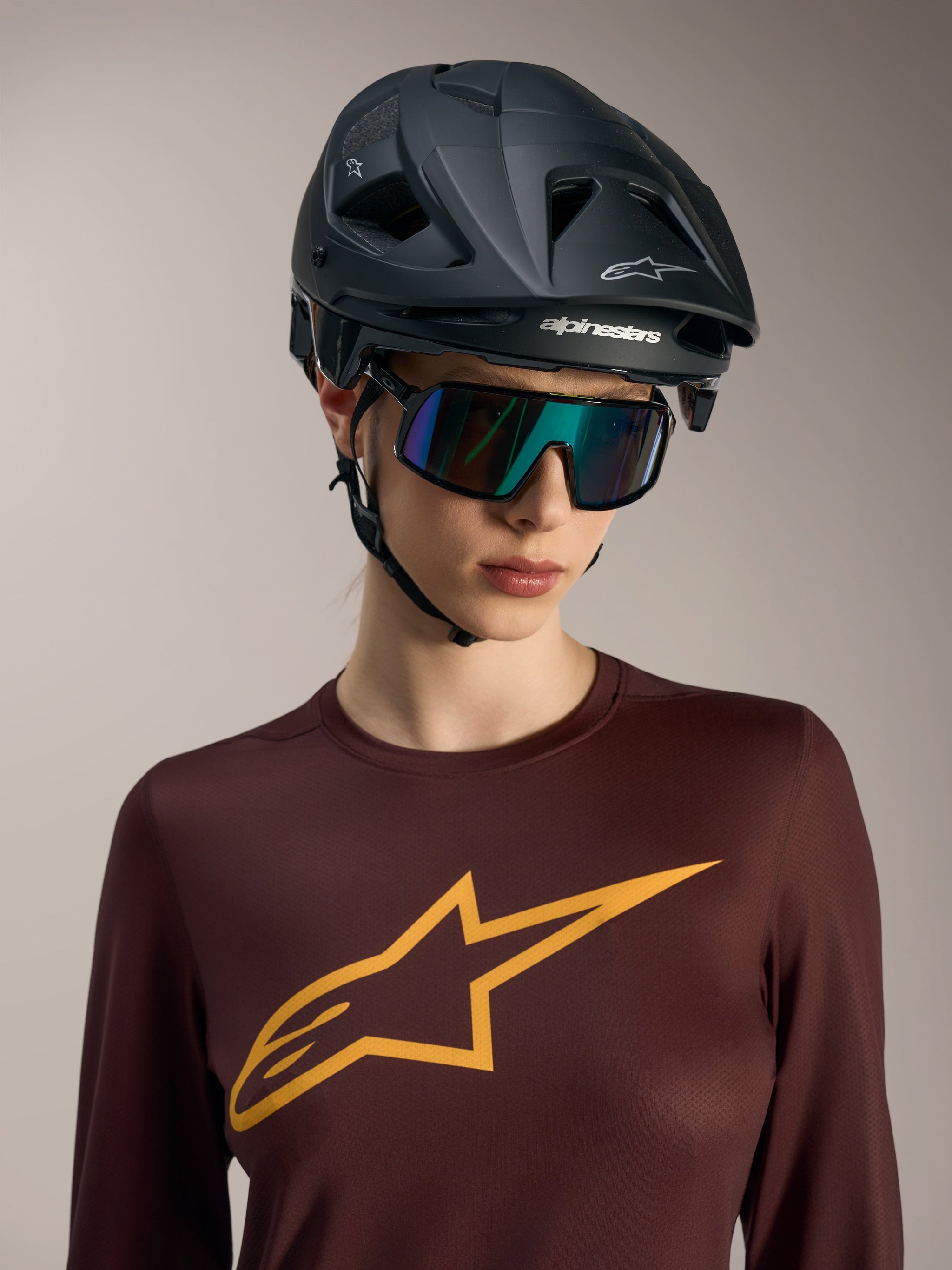 Stella A-Dura Ride Long Sleeve Jersey in bordeaux with a yellow chest logo, worn with an Alpinestars MTB helmet.