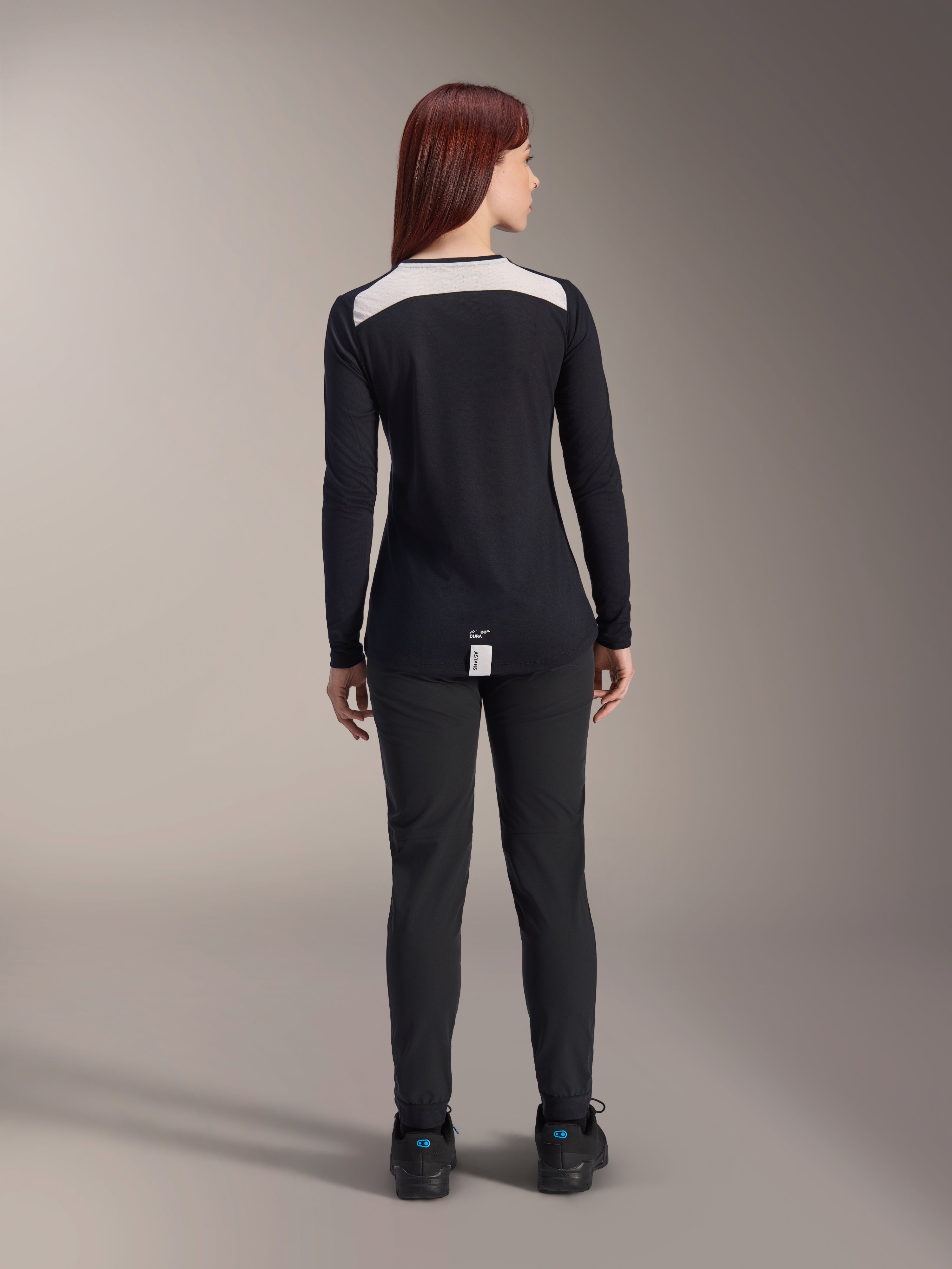 Calças Stella A-Dura Femininas e Camisola Stella A-Dura Elite da Alpinestars, equipamento de MTB, preto com painel branco nos ombros, vista de costas, vestuário técnico para mountain bike, combinado com sapatos pretos