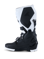 Alpinestars 2026 Tech 7 Enduro Boots, botas de motocross, pretas e brancas, vista de perfil lateral mostrando painéis de proteção em TPU duráveis, secção de aderência medial texturizada com a marca Tech 7 e sistema de fecho com fivelas de alta resistência para condução off-road