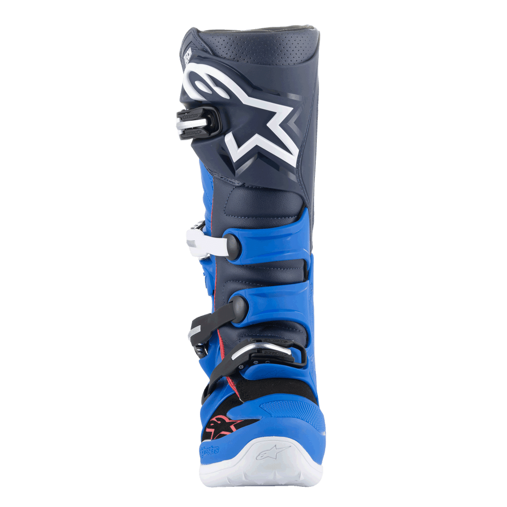 Botas Alpinestars Tech 7, botas de motocross, Alpine Blue, Night Navy e Bright Red, vista frontal apresentando uma parte superior em azul-marinho escuro com um grande logótipo Astars branco, painéis de proteção em TPU azul vivo e um sistema de fecho por fivelas, calçado de alta performance para condução off-road