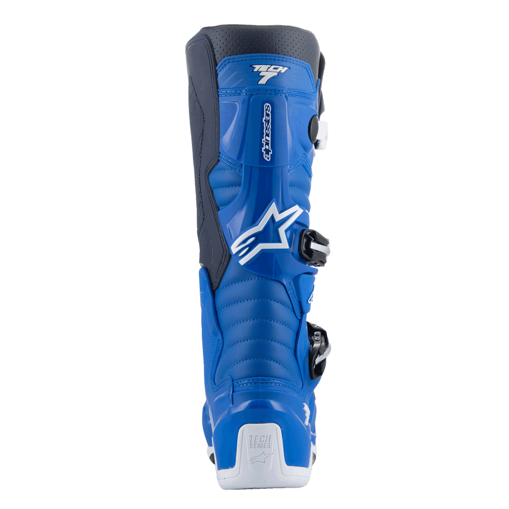 Alpinestars Tech 7 Boots, botas de motocross, azul Alpine e Night Navy com detalhes em branco, vista traseira mostrando o protetor de panturrilha contornado, reforço de calcanhar branco com o logótipo Tech Series e detalhes do sistema de fivelas de entrada lateral.