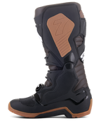 Botas Alpinestars Tech 7 Enduro, botas de motocross e todo-o-terreno, pretas e castanho escuro, perfil lateral exibindo a placa de canela em TPU, sistema de fivelas, painel de aderência medial bege com logótipo e sola robusta específica para enduro para tração.