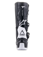 Alpinestars Tech 7 Enduro Drystar Boots, Black and White, rear view showing TPU protective structure, white accordion flex zones, and buckle closure system, featuring Alpinestars branding on the heel and upper