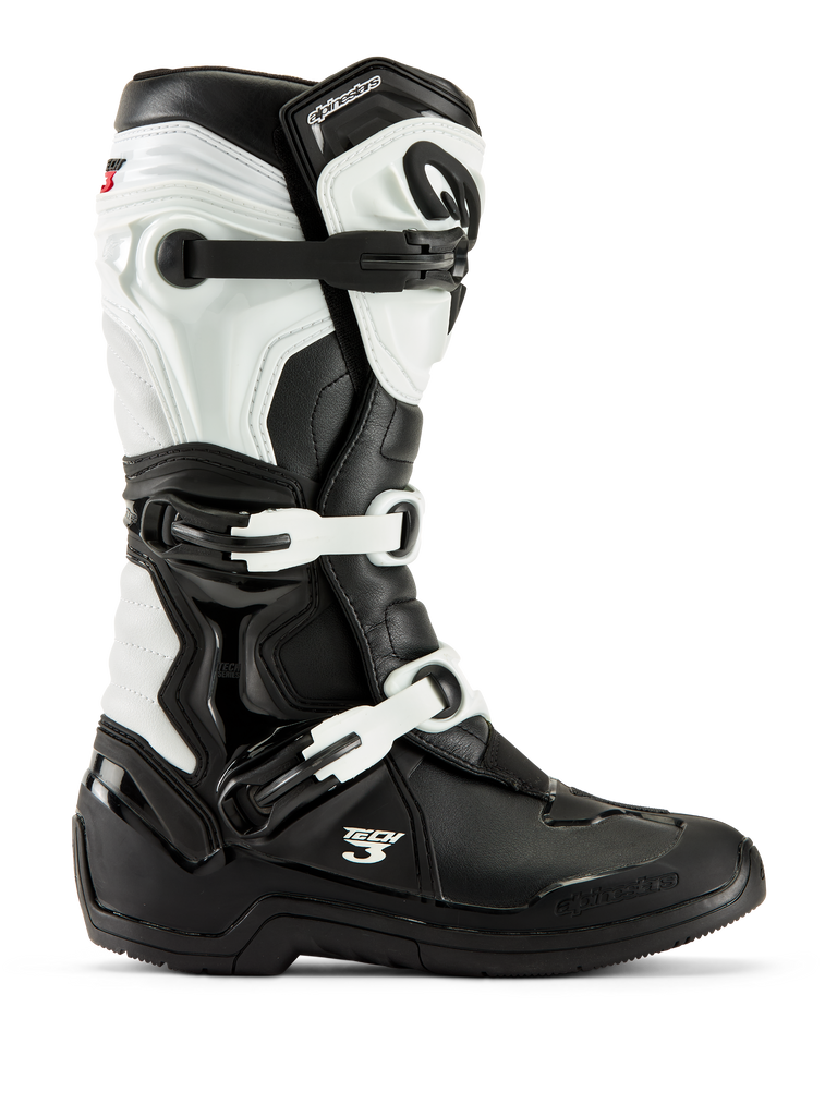 Botas Alpinestars Tech 3, botas de motocross, pretas e brancas, vista de perfil lateral com sistema de fecho de três fivelas, painéis de proteção em TPU e construção sintética durável para corridas off-road