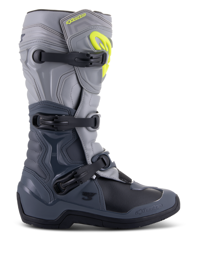 Botas Alpinestars Tech 3, botas de motocross, cinzento escuro, cinzento claro e preto, vista lateral com três fivelas de polímero pretas, painéis de proteção em TPU e logótipo Alpinestars em amarelo vibrante na zona superior da canela