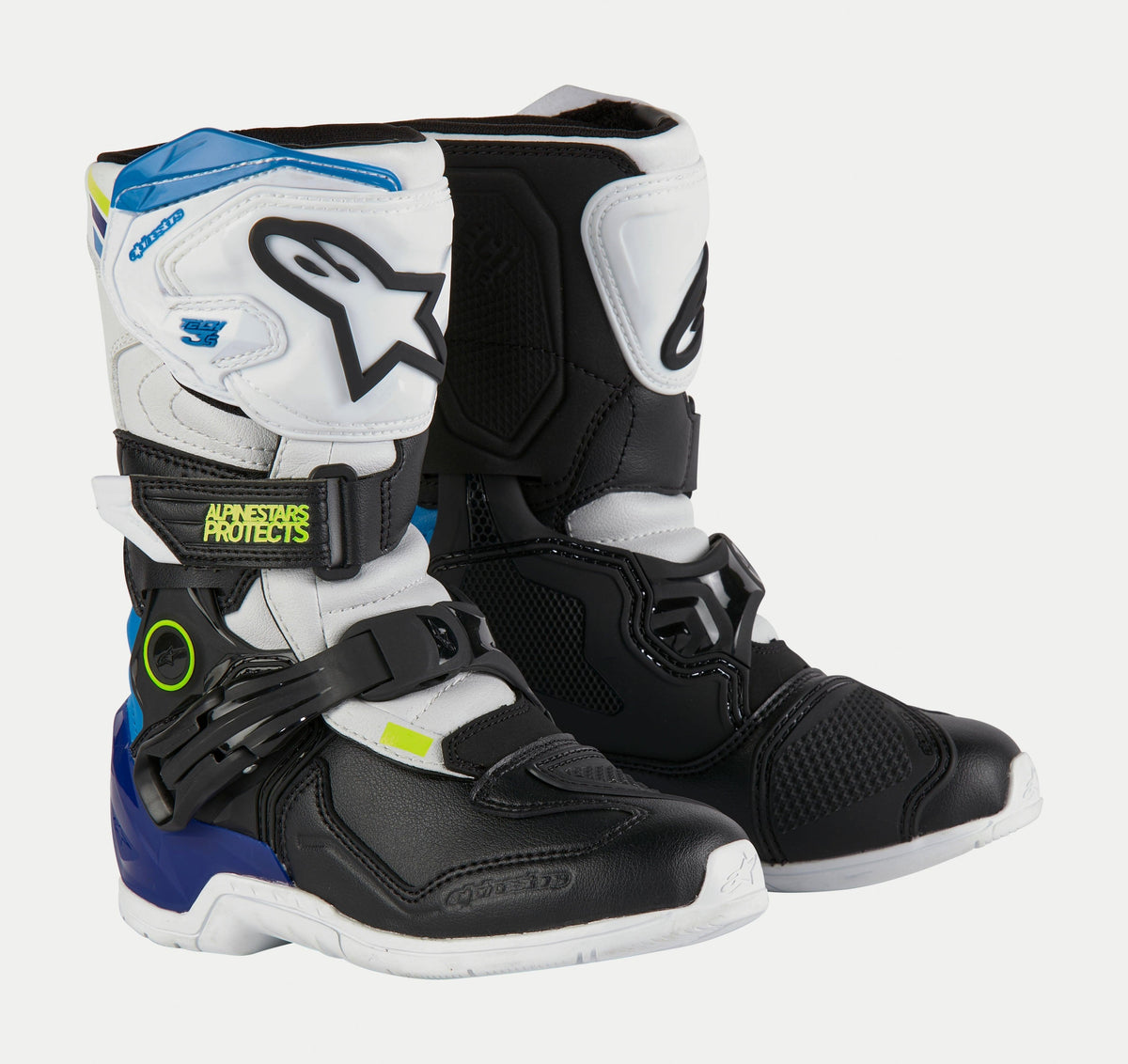 Botas Alpinestars Kids Tech 3S, botas de motocross para criança, em branco, preto e azul esmalte, com painéis protetores em branco e preto, detalhes azuis no calcanhar e no topo, logótipo em amarelo néon e sistema de fecho com fivelas seguras.