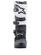 Botas Alpinestars Tech 5, botas de motocross, pretas, cinzento escuro e brancas, vista frontal com sistema de fecho de múltiplas fivelas, painel superior branco com logótipo Astars preto, biqueira reforçada em cinzento escuro e detalhes amarelos subtis