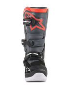 Botas Alpinestars Youth Tech 7S, botas de motocross, pretas e cinzento escuro com detalhes em vermelho fluorescente, vista frontal, com placa de canela em TPU com logótipo de estrela vermelha, sistema de fecho de três fivelas e sola integrada branca, equipamento de proteção durável para todo-o-terreno
