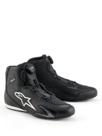 Sapatos Alpinestars Celer, sapatos de condução de moto, pretos e brancos, com o sistema de fecho Rotor, grande logótipo Astar branco na lateral, construção elegante em microfibra técnica para performance desportiva em estrada