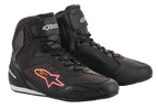 Sapatos Stella Faster-3 Rideknit® da Alpinestars para mulher, pretos com detalhes em amarelo e cor-de-rosa, sapatos de motociclismo com construção tricotada respirável, fecho de atacadores com tira de velcro no tornozelo e painéis de proteção reforçados.