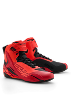 Sapatos Alpinestars MM93 Faster-4, sapatos para motociclismo, vermelho fluo, vermelho brilhante e preto, perspetiva frontal direita, com a marca Marc Marquez 93, fecho de atacadores tradicional com tira de gancho e laço, design desportivo com detalhes protetores em TPU e construção leve em microfibra.