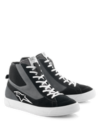 Alpinestars Stated Shoes, sapatos de condução para motociclismo, pretos, cinzentos e brancos, design de cano alto inspirado no estilo skate retro com atacadores brancos e sola de borracha vulcanizada, com o logótipo da Alpinestars na lateral e uma mistura de materiais em camurça e lona.