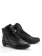 Sapatos Alpinestars Stella Faster-4 Drystar®, sapatos de motociclismo impermeáveis para mulher, pretos e prateados, parte superior em microfibra com fecho de atacadores e tira no tornozelo, reforços protetores em TPU e logótipo Alpinestars.