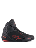 Alpinestars Faster-3 Drystar, sapatos de motociclismo pretos e vermelho fluo, vista lateral de perfil, estilo sapatilha de cano alto com chassis em microfibra leve, membrana Drystar impermeável, logótipo de estrela e branding em vermelho, tira de tornozelo em velcro e detalhes perfurados para respirabilidade.